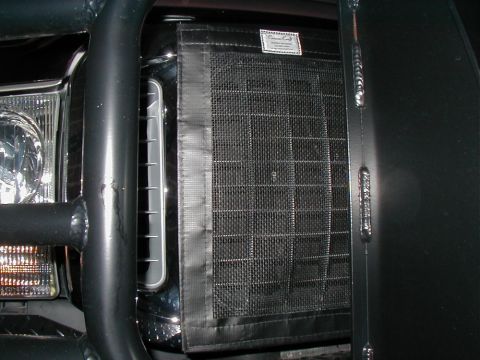 2002 Ford Excursion - Front grille of a 2002 Ford Excursion with a bug screen and bull bar.