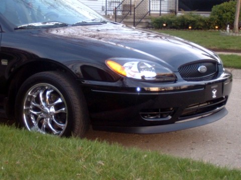 2004 Ford Taurus - Front view of a black 2004 Ford Taurus with chrome wheels.