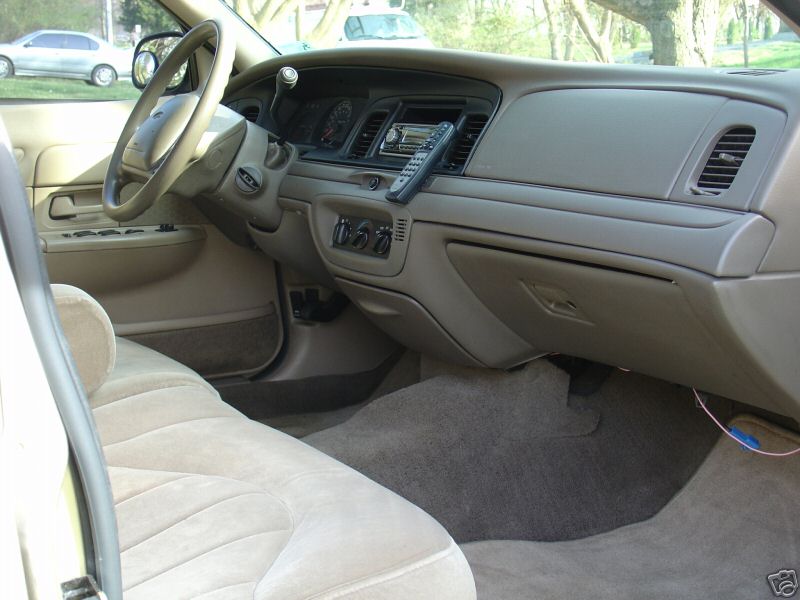 Tan interior of a Ford Crown Victoria viewed from passenger side showing dash and bench seat