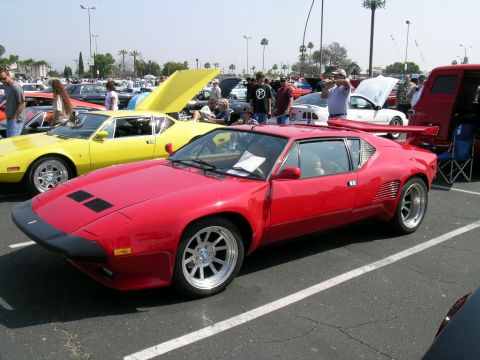 1993 Ford Probe - A red sports car is parked at an outdoor car show with other vehicles and people around.