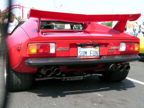 1993 Ford Probe - Rear view of a red De Tomaso Pantera GTS, a prominent rear spoiler and quad exhaust pipes.