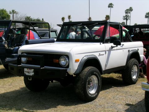 1993 Ford Probe - A white first-generation Ford Bronco is parked outdoors, a black roll cage and aftermarket front bumper.