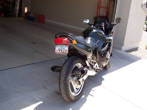 1994 Ford Bronco - A black motorcycle is parked in a garage, with its rear end and license plate clearly visible.