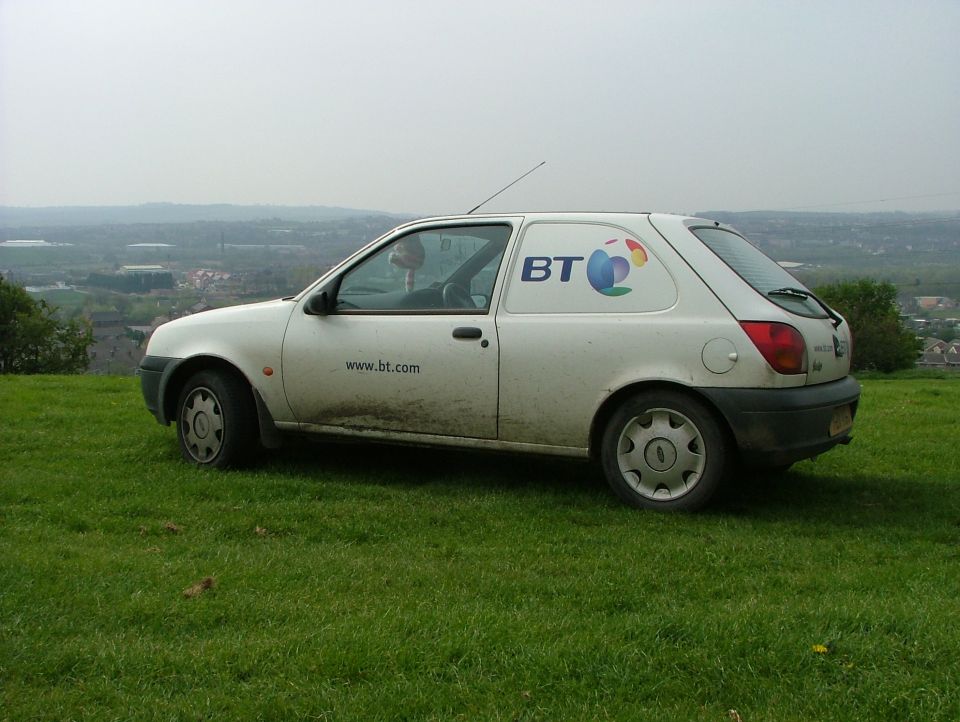White 2001 Ford Fiesta panel van with BT logo and www.bt.com on the side, parked on a grassy hill