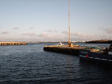 1996 Ford Bronco - A boat is moored at a pier in a harbor under a clear sky with distant land visible.