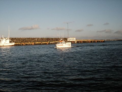 1996 Ford Bronco - Boats navigate a harbor with a breakwater and pier under a partly cloudy sky.
