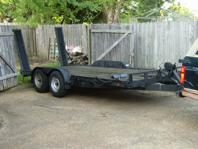 Car trailer with ramps, parked outdoors