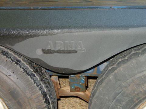 1995 Ford Bronco - Close-up of a trailer's wheel well, revealing the embossed name "ARMA" and dual tires.
