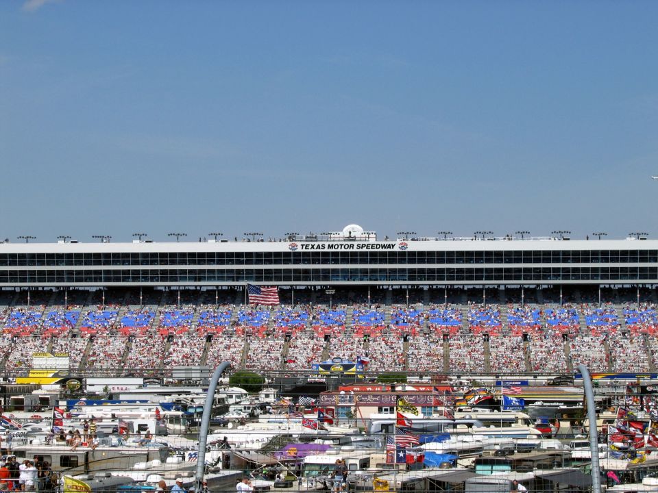 Texas Motor Speedway grandstands filled with spectators and a busy parking lot below
