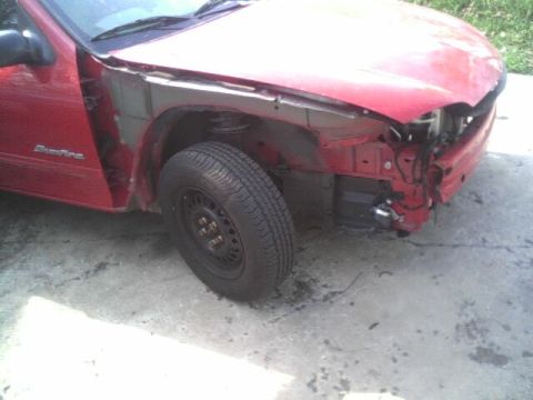 2005 Chevrolet Cavalier - The front end of a red car is heavily damaged, with the bumper and fender removed.