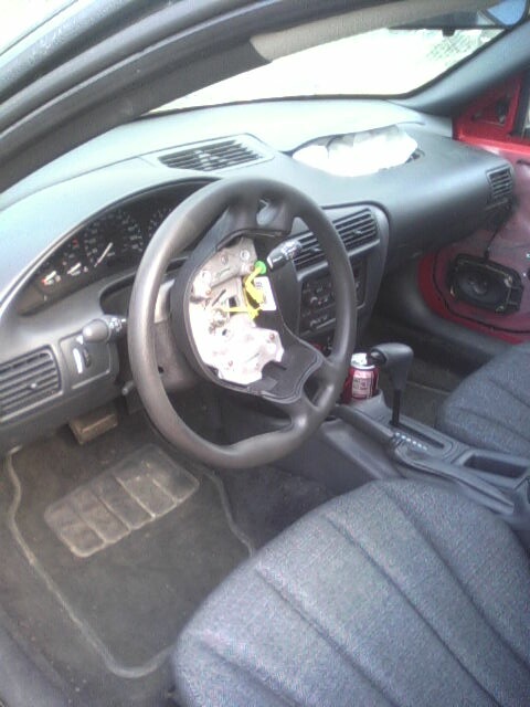 2005 Chevrolet Cavalier - The interior of the vehicle shows damage to the steering wheel and dashboard area.