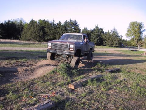 1983 Ford Bronco - Modified Ford pickup truck navigates a challenging off-road obstacle course.