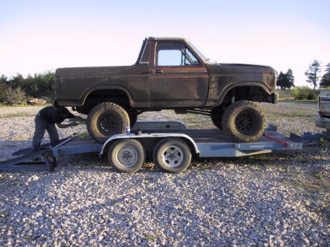 1983 Ford Bronco - Ford Bronco being loaded onto a trailer with a person assisting.