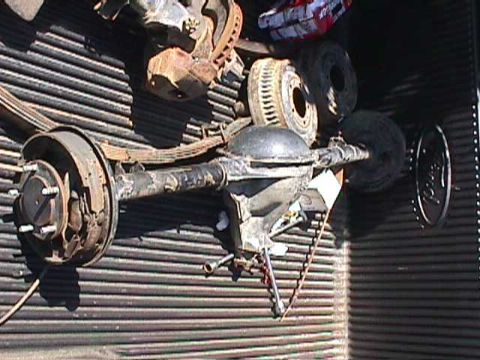 1984 Jeep Wrangler - Rear axle assembly with leaf springs and brake drums, likely from a truck or SUV.