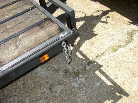 1995 Ford Bronco - A close-up view of a trailer's hitch and chains, with a shadow cast on the ground.