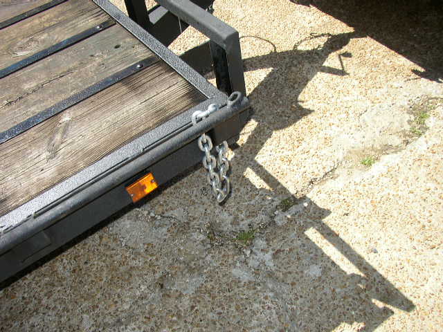 Trailer hitch with metal frame and wooden planks, showing chains and an orange reflector