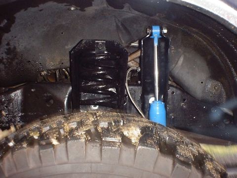 1988 Ford Bronco - Close-up view of the suspension system, showing a coil spring and shock absorber.