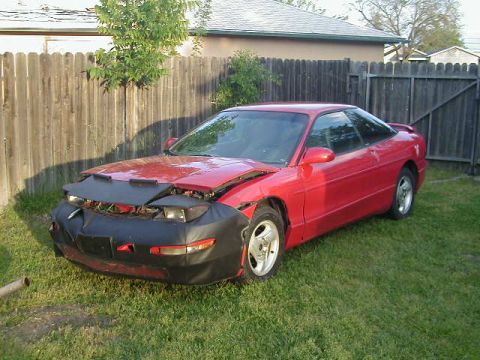 1993 Ford Probe - Red 1993 Ford Probe parked on grass with a black cover over its damaged front end.