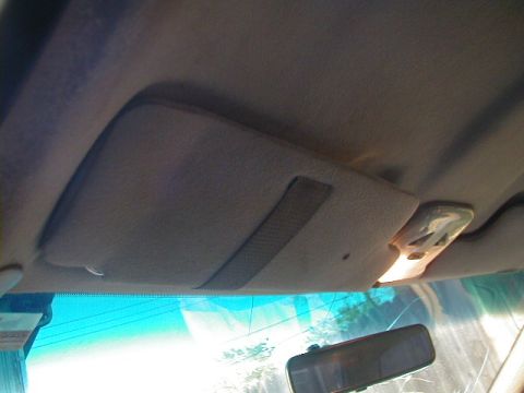 1993 Ford Probe - Interior view of a car's ceiling, showing a sun visor and an illuminated overhead light fixture.