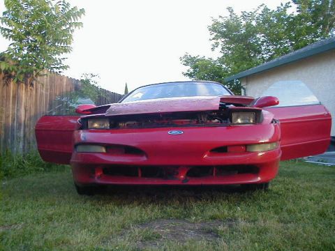 1993 Ford Probe - This red 1993 Ford Probe is shown from the front with its hood and driver's door open.