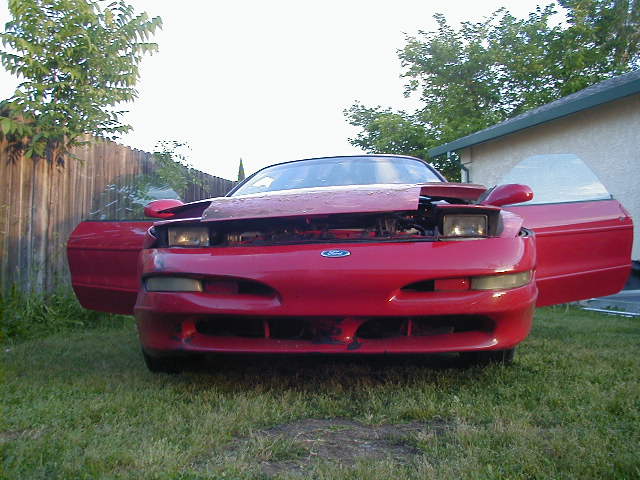 Red 1993 Ford Probe front view, hood and driver's door open