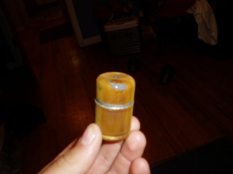 1990 Ford Bronco - A person holds a cylindrical fuel tank cap with a silver band.