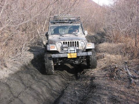 1985 Ford Bronco - John Flexing with the sway bars connected. Notice the tires off the ground, and he's not touching the fenders.