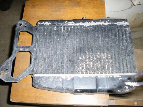 1990 Ford Probe - A radiator part is shown on a wooden surface.