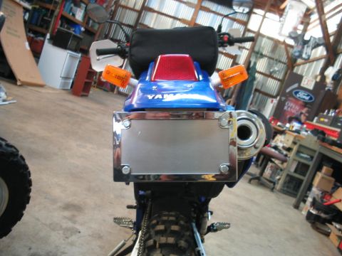 1991 Ford Bronco - Rear view of a blue Yamaha motorcycle, a chrome license plate holder and orange turn signals.