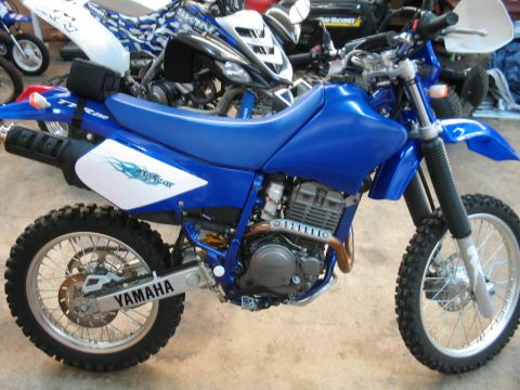 1991 Ford Bronco - A blue Yamaha dirt bike is parked indoors, with other ATVs and equipment visible in the background.