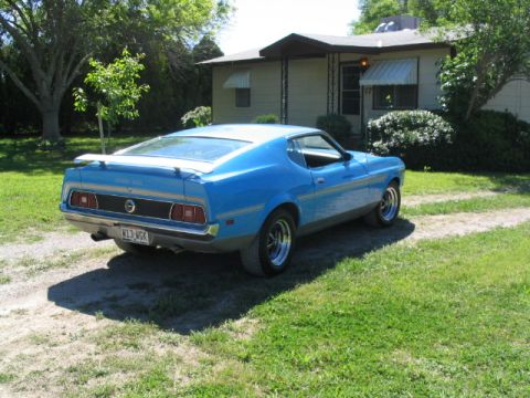 1972 Ford Mustang - This blue 1971 Ford Mustang Mach 1 is parked in a driveway with a house in the background.