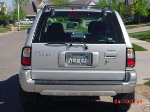 2000 Isuzu Rodeo - Rear view of a silver 2000 Isuzu Rodeo, showing the taillights, license plate, and roof rack.