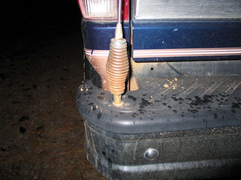 1995 Ford Bronco - Close-up of a vehicle's rear bumper and antenna, showing dirt and water marks.