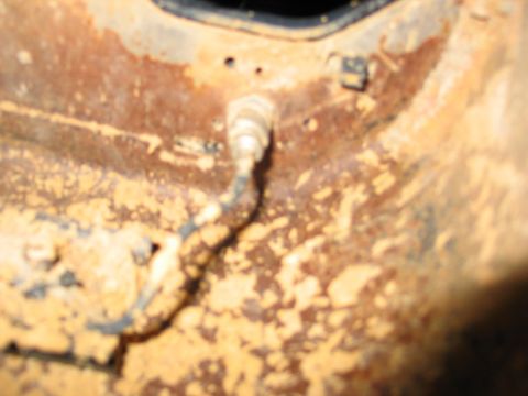 1995 Ford Bronco - Close-up of rusted metal with a sensor and wire attached.