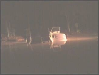 1995 Ford Bronco - A white SUV sits partially submerged in water with its doors open.