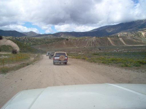 1988 Ford Bronco rear view on dirt road with two other SUVs