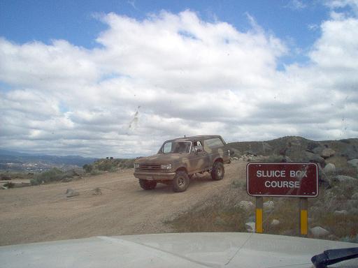 1988 Ford Bronco on dirt road near Sluice Box Course sign