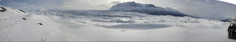 2003 Jeep TJ - A vehicle's rear tire and fender are visible in the foreground of a vast, snow-covered mountainous landscape.