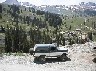 1993 Ford Bronco - A classic Ford Bronco is seen parked on a dirt road with a scenic mountain landscape behind it.