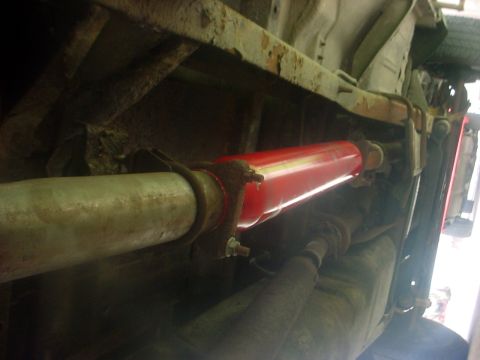 1973 Ford Ranchero - A red exhaust muffler is visible on the underside of a vehicle, attached to the exhaust pipe.