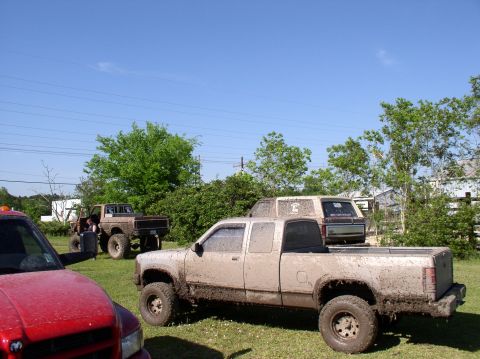 2000 Chevrolet Tahoe - Multiple off-road vehicles are covered in mud after an outing.