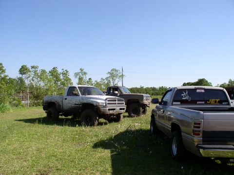 2000 Chevrolet Tahoe - Several trucks are parked in a grassy field, appearing to be ready for or having just finished some off-road activity.