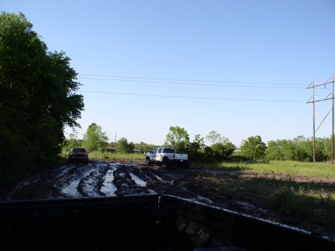 2000 Chevrolet Tahoe - Trucks navigate a challenging muddy terrain on a bright, clear day.