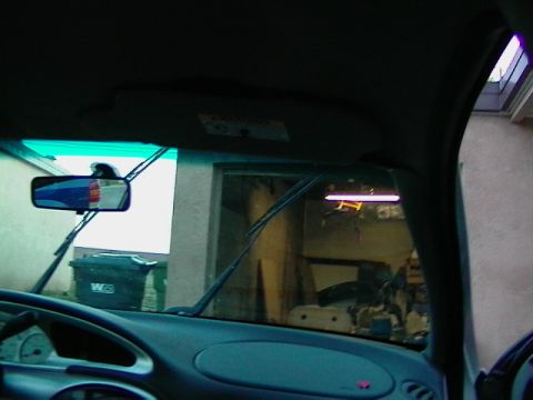 1999 Ford Taurus - Looking out the windshield of a car, showing a garage scene with a trash bin visible.