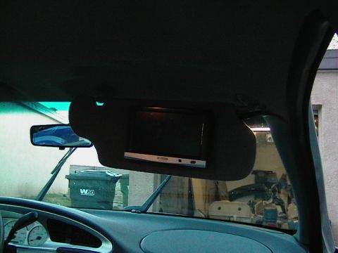 1999 Ford Taurus - Interior view of a car's sun visor with an integrated screen, dashboard, and windshield.