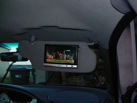 1999 Ford Taurus - The visor in this car has been modified with an integrated screen, displaying a scene from a movie or show.