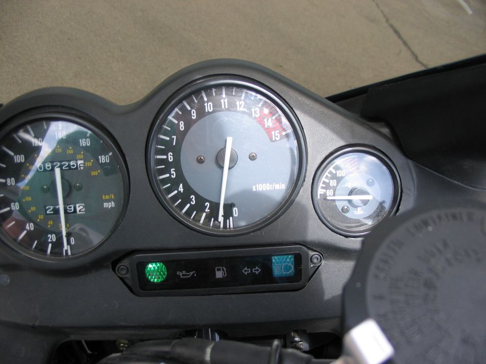 Motorcycle dashboard with speedometer, tachometer, and fuel gauge. Shows 08225 miles and 2792 hours