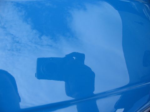 1997 Yamaha YT60 Tri-Moto - A camera is reflected in the glossy blue paint of a vehicle's body panel.