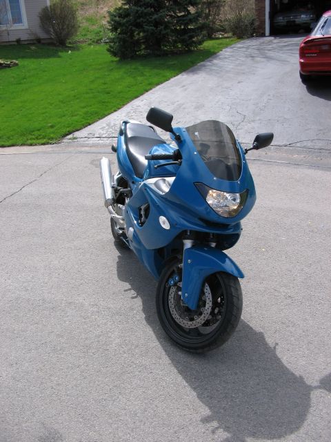 1997 Yamaha YT60 Tri-Moto - A blue sport motorcycle is parked on a driveway, with a house and lawn in the background.