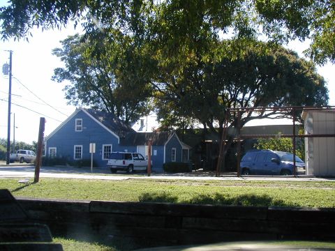 2000 Ford Crown Victoria - Two vehicles, a white SUV and a blue minivan, are parked in front of residential buildings on a sunny day.